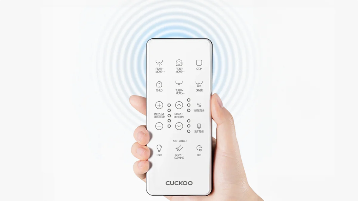 A hand holding a bidet remote control, featuring labeled buttons for various washing, drying, and temperature settings. (CBT-I1030RW)