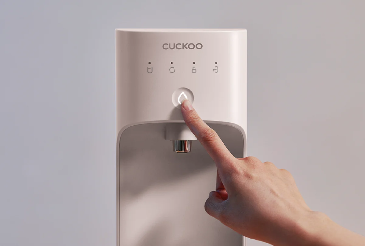 Close-up of a hand pressing the illuminated control button on the CUCKOO NANO+ Signature Water Purifier. (CP-AKN011)